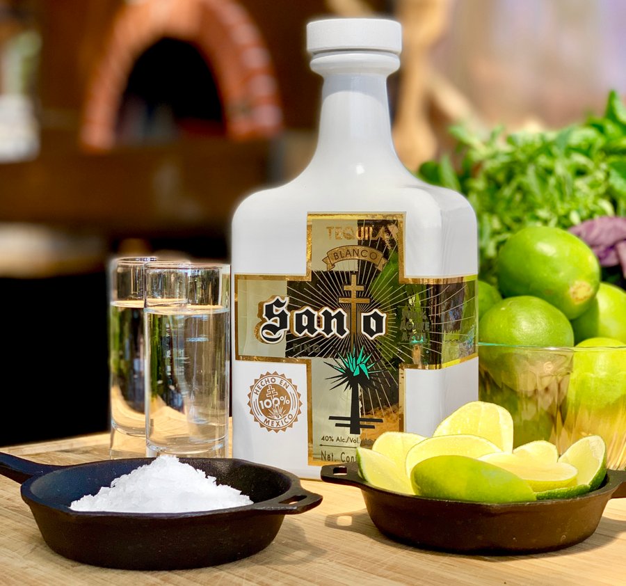 Bottle of Santo Blanco Tequila with salt and limes